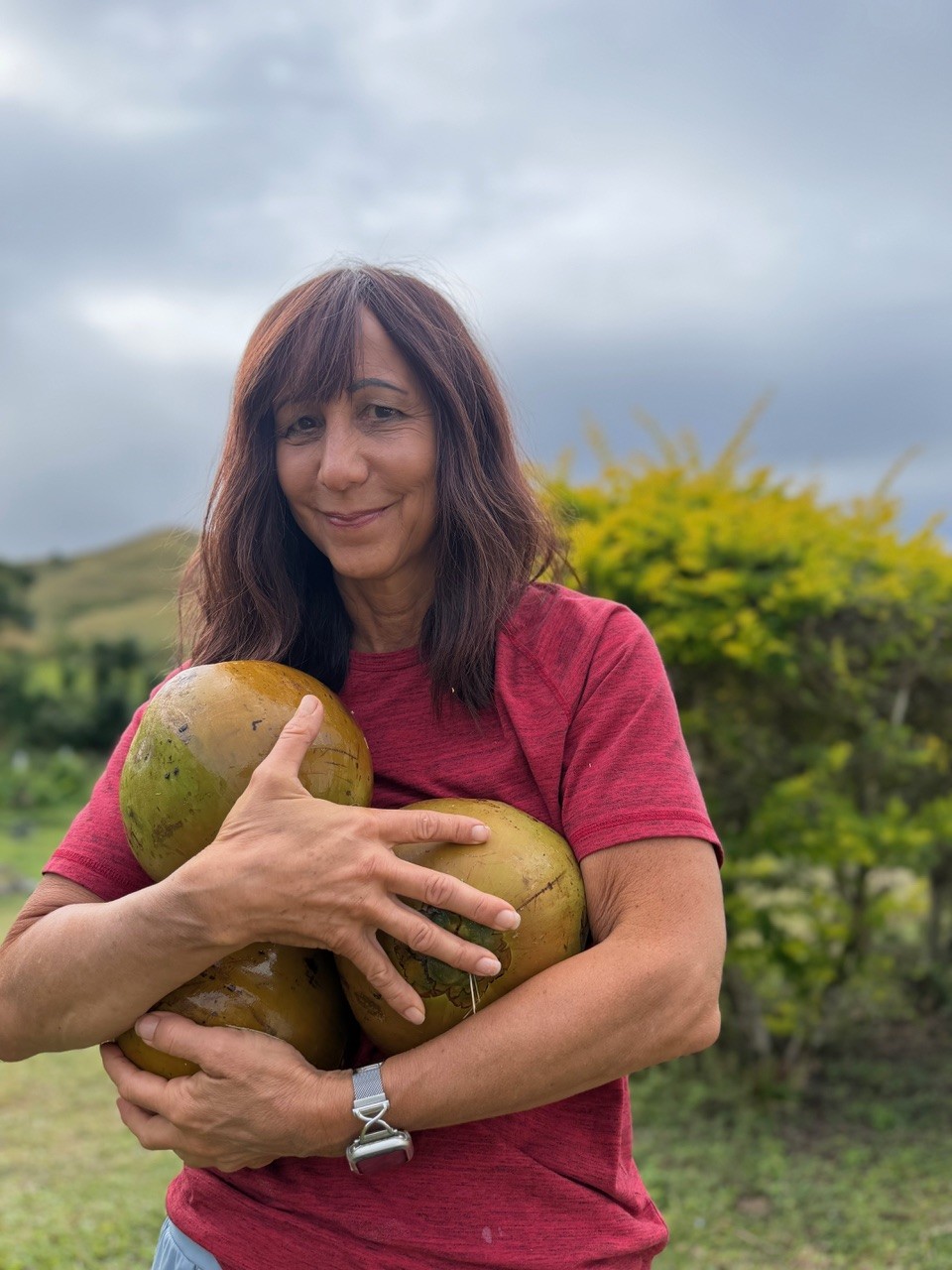 Luisa Szakacs holding fresh coconuts from a Fiji farm during her mission trip.